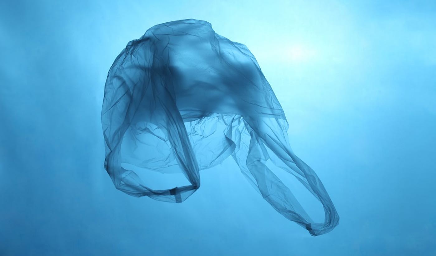 Plastic bag in blue water, garbage under water, plastic pollution of the oceans