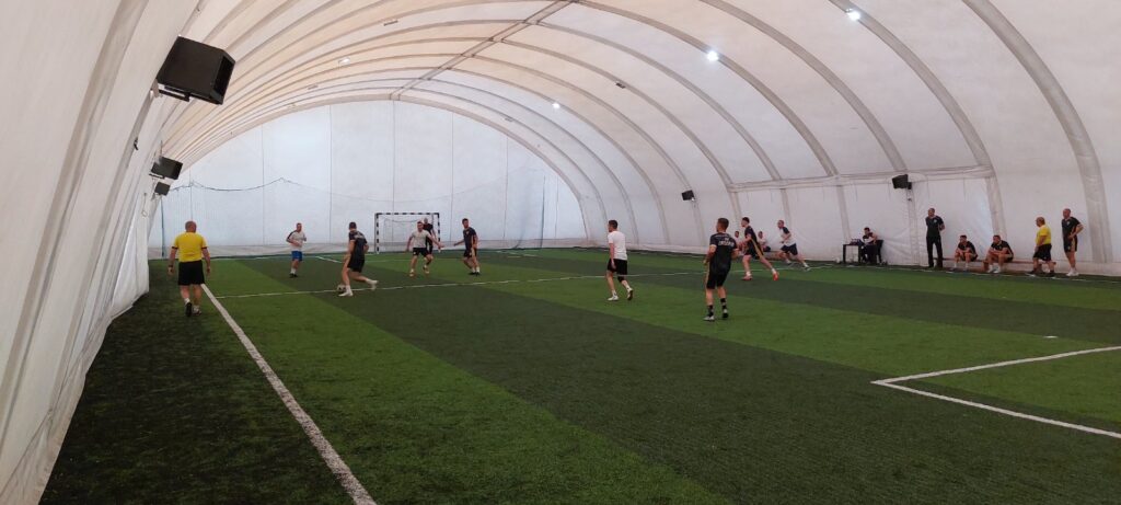 Trening fudbala u zatvorenom, sportska hala sa igračima u akciji.