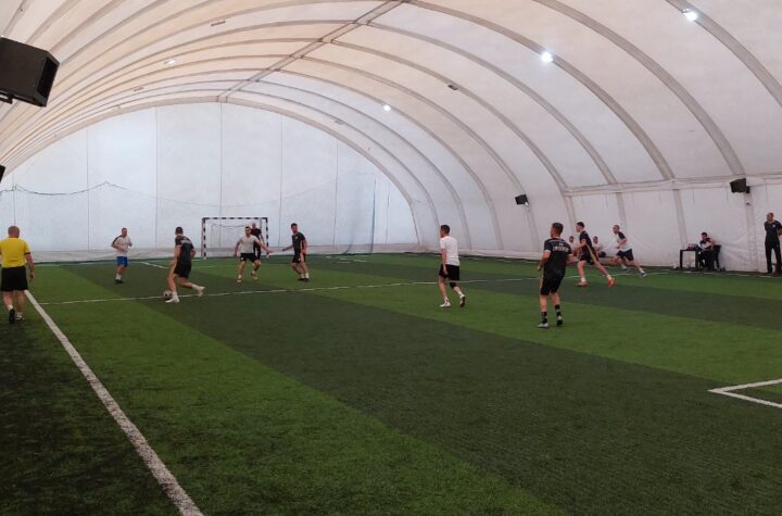 Trening fudbala u zatvorenom, sportska hala sa igračima u akciji.