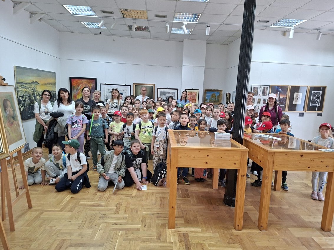 Grupa dece u muzeju tokom edukativne posete, razgledaju izložbe.