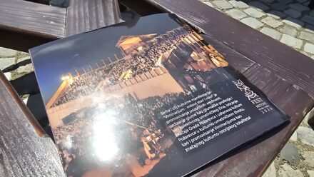 Noćni događaj na otvorenom sa osvetljenjem i publikom.