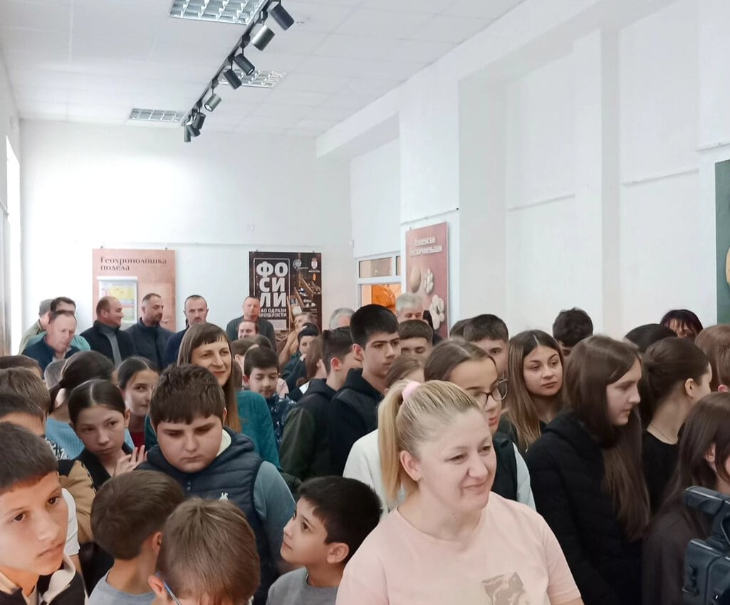 Grupa učenika i nastavnika na školskom događaju u učionici.