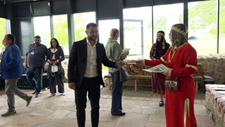 Osoba u tradicionalnoj nošnji deli dokumente na događaju u Požarevcu.