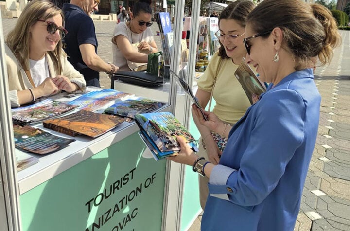 Grupa ljudi na štandu Turističke organizacije Požarevac, razgledaju brošure i informišu se o lokalni.