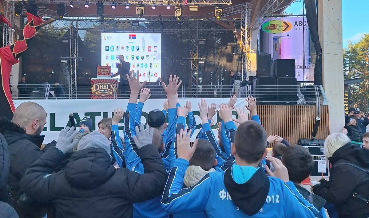 Grupa ljudi na koncertu u Požarevcu sa podignutim rukama, pozornica u pozadini.