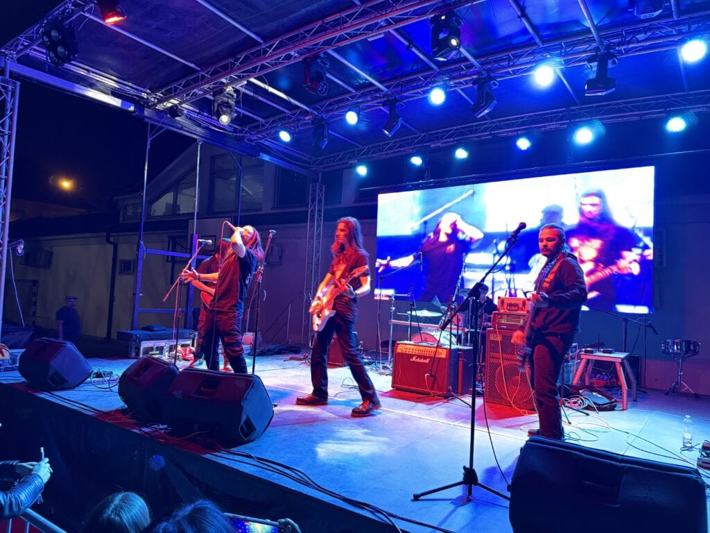 Muzički bend na koncertu uživo u Požarevcu, osvetljenje i scena.