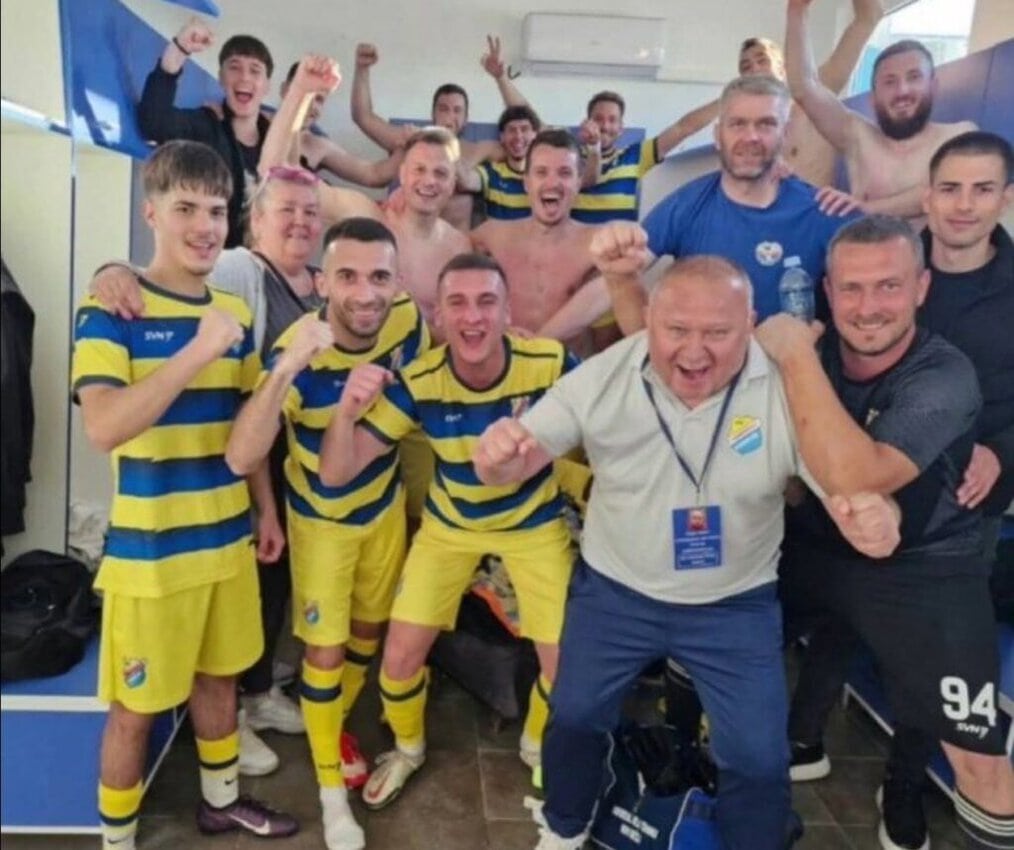Tim fudbalera slavi u svlačionici nakon pobede.