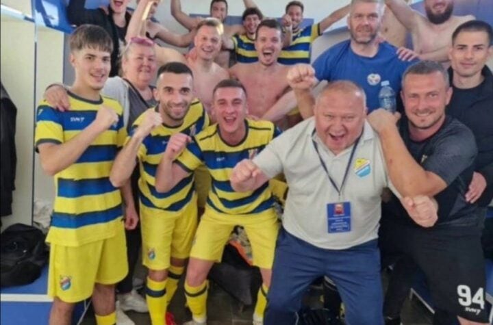 Tim fudbalera slavi u svlačionici nakon pobede.