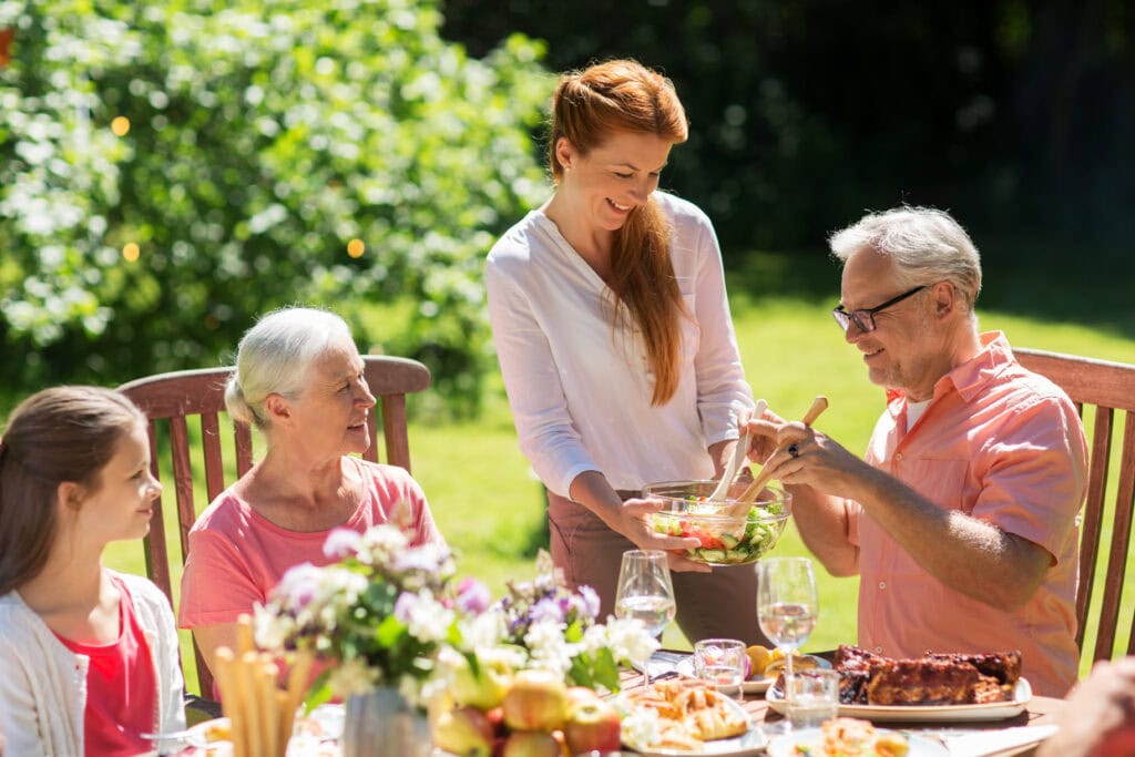 Happy family having dinner or summer garden party